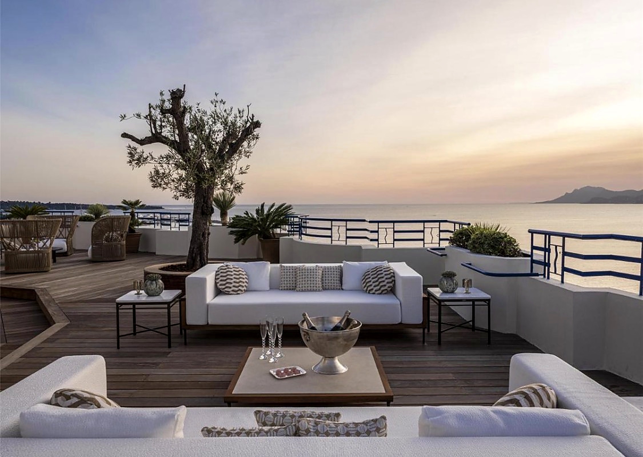 Rooftop terrace at sunset with champagne above the bay